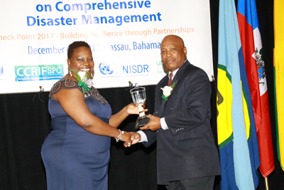 The Hon. Samantha Marshall, Minister of Social Transformation and Human Resource Development, Antigua and Barbuda and Chair of the CDEMA Council of Ministers (left) presenting the CDEMA Council Award to General Earl Arthurs. 